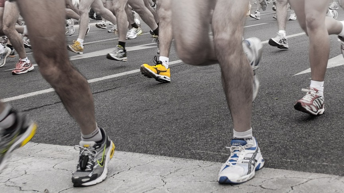 Foto: aumod, no Pixabay[/img]</p>
<h2 id="-ente-terrissar-ob-o-entro-de-ravidade">Tente Aterrissar Sob o Centro de Gravidade</h2>
<p>O segredo para uma corrida BS (boa e saudável) não é o tipo de pisada, mas <strong>onde o pé toca o solo em relação ao seu corpo</strong>. Uma aterrissagem sob o centro de gravidade reduz o impacto e melhora a economia de corrida, independentemente de você ser <em>heel striker</em> ou <em>midfoot striker</em>.</p>
<p>A forma como o pé toca o solo é decisiva para evitar lesões e melhorar a eficiência da corrida. O objetivo é manter a aterrissagem próxima ao centro de gravidade, sem frear o movimento.</p>
<p>Falar assim é fácil, mas <strong>como saber qual o meu tipo de pisada</strong>? Vamos dar três receitas:
1. <strong>Filme sua corrida de lado:</strong> Se o pé estiver aterrissando muito à frente do quadril, você está fazendo <em>overstriding</em>.
2. <strong>Preste atenção ao som:</strong> Um “barulho” alto ao pisar indica que você está freando o movimento e desperdiçando energia.
3. <strong>Aumente a cadência:</strong> Manter entre 170 e 180 SPM naturalmente reduz o <em>overstriding</em>, já que encurta a passada. </p>
<p>Agora, pega esse <strong>exercício para ajustar sua pisada</strong>: Corra descalço ou com um tênis leve em uma superfície plana (como uma quadra) por 1 a 2 minutos. O corpo instintivamente aterrissa mais próximo ao centro de gravidade. Depois, leve essa sensação para seus treinos normais, aumentando gradualmente a distância. </p>
<p>Esse tipo de prática ajuda a corrigir a sobrepassada sem exigir mudanças bruscas na pisada, tornando a corrida mais eficiente e segura.</p>
<h2 id="-omo-daptar-ua-isada-ao-erreno">Como Adaptar Sua Pisada ao Terreno</h2>
<p>Um simples treino urbano oferece uma variedade de terrenos (calçadas, rampas, asfaltos, etc), e cada um exige ajustes na técnica de corrida.</p>
<p><strong>Correndo no Asfalto:</strong> O asfalto é uma superfície dura e muitas vezes irregular, especialmente em cidades como São Paulo e Rio. Para quem tem pisada de calcanhar (<em>heel strike</em>), o cuidado principal é usar tênis com bom amortecimento, como os modelos Asics Gel ou Hoka Bondi. Além disso, evitar passadas longas e manter uma cadência mais alta ajuda a reduzir o impacto e proteger articulações. </p>
<p><strong>Correndo em Trilhas:</strong> Nas trilhas, o terreno instável com raízes e pedras exige mais atenção. Aqui, uma pisada com o meio do pé ou antepé pode oferecer maior estabilidade. O segredo é reduzir o ritmo e focar em passos curtos, o que diminui o risco de torções e melhora a adaptação ao solo irregular. </p>
<p><strong>Correndo na Esteira:</strong> Na esteira, o movimento da lona que “puxa” o pé para trás pode incentivar o <em>overstriding</em>. Para compensar, aumente a inclinação para 1% a 2%, simulando melhor a corrida ao ar livre. Manter uma cadência alta também ajuda a evitar a sobrepassada e garante que o treino seja mais eficiente e seguro. </p>
<p>Em resumo: cada terreno pede uma estratégia diferente. Ajustar cadência, postura e tipo de pisada ao ambiente é o que garante evolução sem abrir espaço para lesões.</p>
<p>[img]pixabay_2661560.jpg